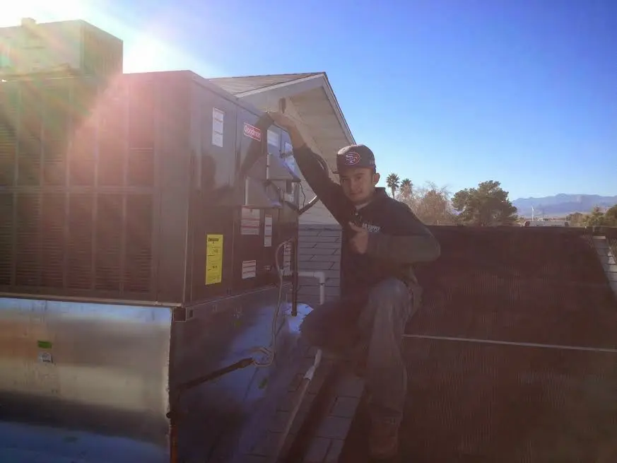 HVAC technician performing AC Tune-Up on a rooftop unit in Fairfield Glade