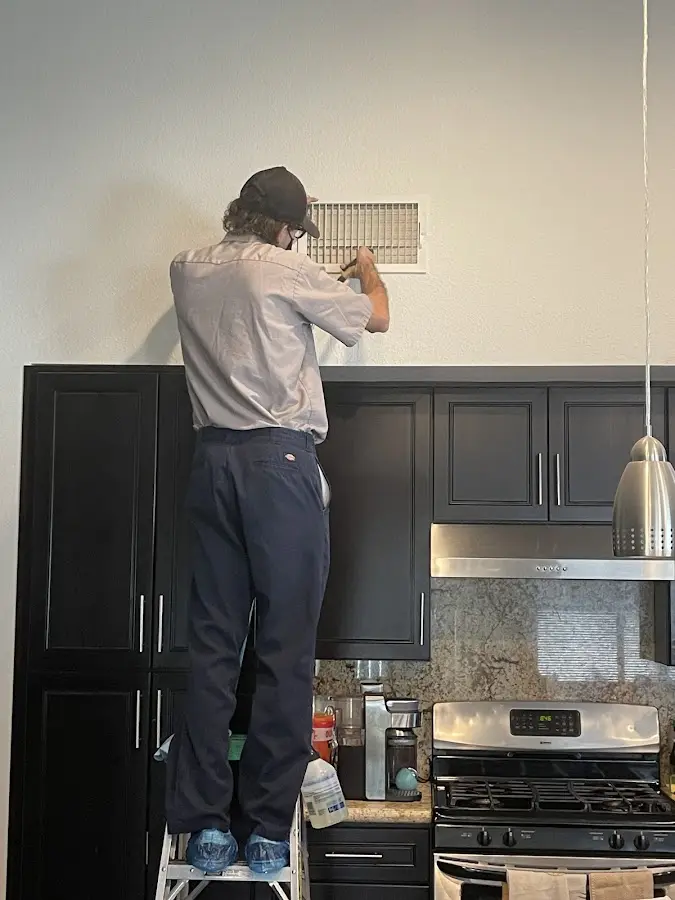 Technician inspecting an air vent during HVAC service in Fairfield Glade